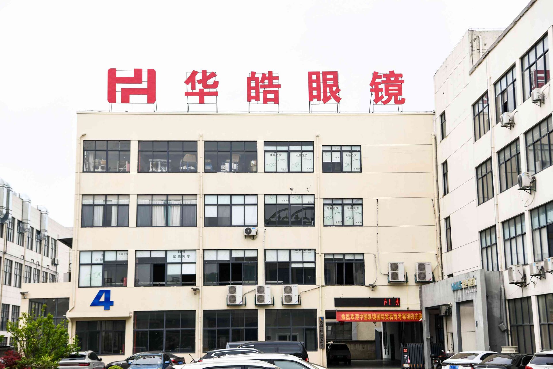 HAO Eyewear factory main entrance with company signage and welcome banner for the China Eyewear International Trade Summit in Danyang