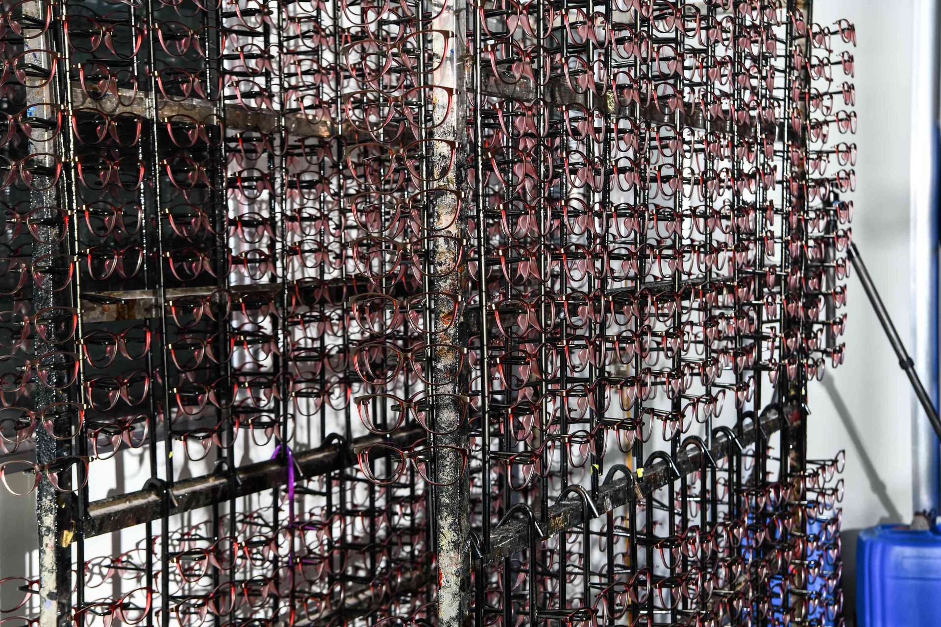Massive rack of eyewear frames awaiting paint finishing at HAO Eyewear